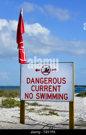 Un prominente e grande cartello recita "pericoloso corrente non nuoto' su una spiaggia in ingresso nel sud-ovest della Florida in Boca Grande, FL, Gasparilla Island Foto Stock