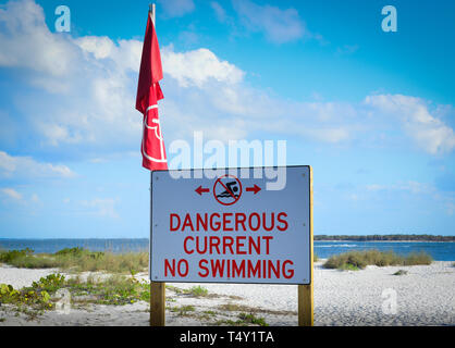 Un prominente e grande cartello recita "pericoloso corrente non nuoto' su una spiaggia in ingresso nel sud-ovest della Florida in Boca Grande, FL, Gasparilla Island Foto Stock