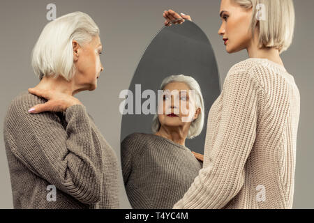 Bella bella donna anziana ammirando il suo look Foto Stock