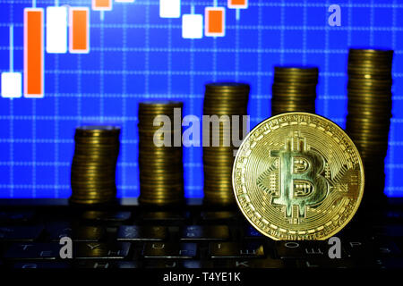 La crescita finanziaria concetto con golden Bitcoins scala sul forex sfondo grafico. Denaro virtuale, Cryptocurrency Foto Stock