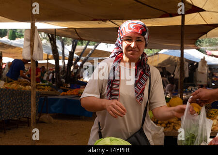 Kas, Turchia - 17 Maggio 2016: donna matura acquistare verdure in un mercato aperto a Kas. Foto Stock