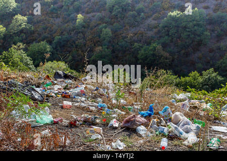 Le bottiglie di plastica, sacchetti e altri rifiuti lungo la strada. Cestino in strada. Concetto di inquinamento ambientale Foto Stock