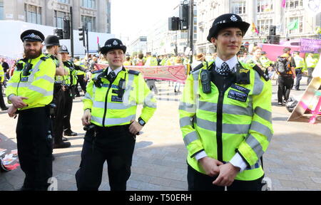 Londra, Regno Unito. Xix Apr, 2019. Aumentata cordone di polizia visto durante la dimostrazione.gli attivisti ambientali dalla ribellione di estinzione movimento occupare della Londra Oxford Circus per un quinto giorno. Gli attivisti parcheggiato una barca rosa nel mezzo della trafficata Oxford Circus road junction bloccando le strade e provocando il caos del traffico. Credito: Keith Mayhew/SOPA Immagini/ZUMA filo/Alamy Live News Foto Stock