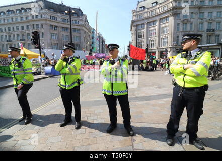 Londra, Regno Unito. Xix Apr, 2019. Aumentata cordone di polizia visto durante la dimostrazione.gli attivisti ambientali dalla ribellione di estinzione movimento occupare della Londra Oxford Circus per un quinto giorno. Gli attivisti parcheggiato una barca rosa nel mezzo della trafficata Oxford Circus road junction bloccando le strade e provocando il caos del traffico. Credito: Keith Mayhew/SOPA Immagini/ZUMA filo/Alamy Live News Foto Stock