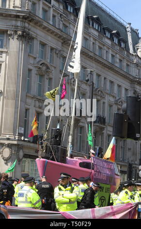 Londra, Regno Unito. Xix Apr, 2019. La polizia visto accanto ad una barca di rosa durante la dimostrazione.gli attivisti ambientali dalla ribellione di estinzione movimento occupare della Londra Oxford Circus per un quinto giorno. Gli attivisti parcheggiato una barca rosa nel mezzo della trafficata Oxford Circus road junction bloccando le strade e provocando il caos del traffico. Credito: Keith Mayhew/SOPA Immagini/ZUMA filo/Alamy Live News Foto Stock