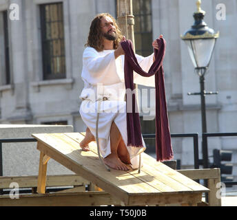 Gesù Cristo durante una performance di 'La Passione di Gesù " da Wintershall giocatori in Trafalgar Square. Circa ventimila persone pranzo della Londra Trafalgar square per la performance annuale della Passione di Gesù mediante la Winterhall giocatori. La rievocazione della vita di Gesù dal suo arrivo a Gerusalemme per la sua crocifissione e resurrezione finale viene eseguita da un cast più di cento attori e volontari per gratis ogni Venerdì Santo. Foto Stock