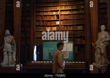 Vienna, Austria. Xviii Apr, 2019. Un visitatore viene visto allo stato Sala della Biblioteca Nazionale Austriaca a Vienna, Austria, 18 aprile 2019. Lo stato Sala della Biblioteca Nazionale Austriaca a Vienna è una delle più belle e antiche biblioteche nel mondo. Lo stato Hall, ufficialmente completati nel 1730, è un tesoro di architettura barocca, con splendidi murales in tutta la hall e 200.000 libri spanning a partire dall'anno 1501 al 1850. Credito: Guo Chen/Xinhua/Alamy Live News Foto Stock