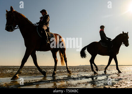 Cuxhaven, Germania. Xx Apr, 2019. Alina (l) e Madeline sono a mezzogiorno con il bel tempo e di bassa marea con i loro cavalli nel velme. Credito: Mohssen Assanimoghaddam/dpa/Alamy Live News Foto Stock