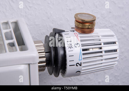 Il radiatore con le monete in euro e di termostato Foto Stock