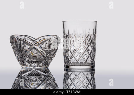 Svuotare il vetro cristallo e vaso su uno sfondo grigio con un riflesso speculare Foto Stock