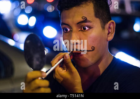 Ritratto di un giovane clown mettendo sui mustaches con il trucco. Foto Stock