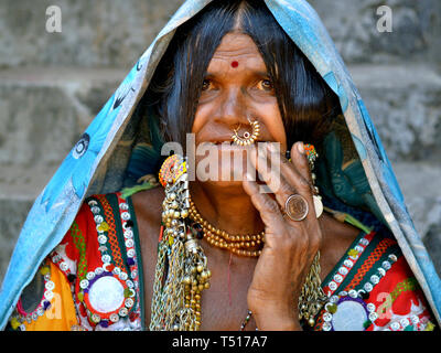 Antichi Indiani Banjara donna tribale indossa gioielli naso, ricamato colorato indumento tribali e un copricapo con molti pulsanti, lucido e i dischi e i talloni. Foto Stock