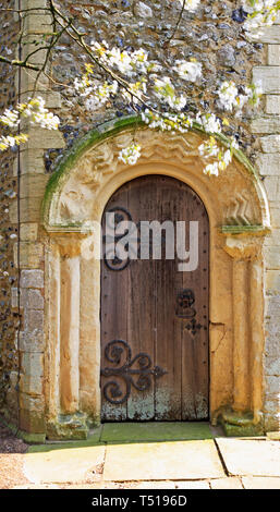 Un Norman porta all'estremità occidentale di ridondante e restaurata chiesa di San Nicola a Buckenham, Norfolk, Inghilterra, Regno Unito, Europa. Foto Stock