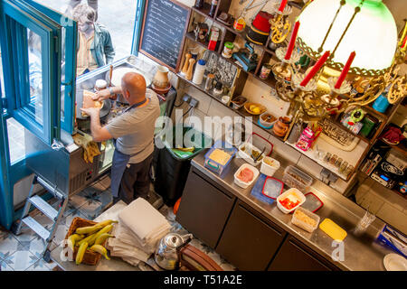 Uomo che fa le crepes per i turisti nel suo Creperia, Marais, Parigi, Francia
