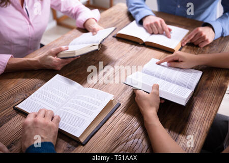 Gruppo di persone che leggono la Bibbia sulla scrivania in legno Foto Stock