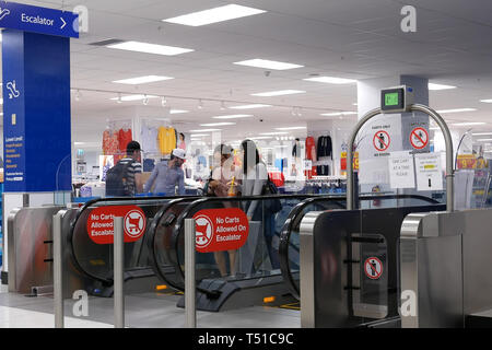 Coquitlam, BC, Canada - 31 Marzo 2019 : il movimento di persone di prendere le scale mobili nei moderni interni urbani all'interno Walmart store Foto Stock