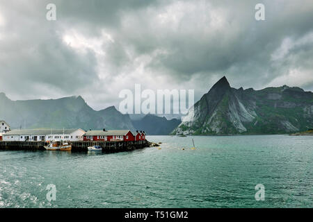 Il legno rosso Rorbu / pescatori di cabine di Hamnoy villaggio di pescatori e sul paesaggio Moskenesøya nelle Isole Lofoten Nordland in Norvegia. Foto Stock