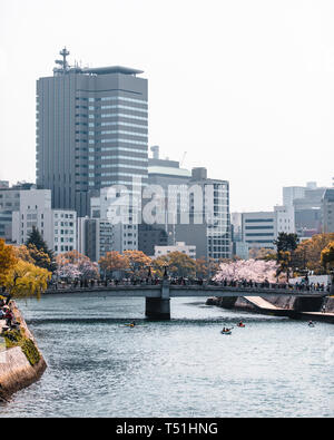 Riverside alla Cupola della Bomba Atomica a Hiroshima, Giappone durante la fioritura dei ciliegi stagione Foto Stock