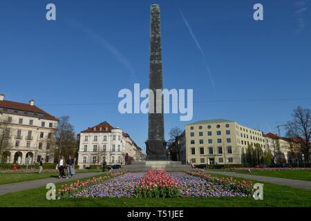 Obelisco con aiuole di fiori nella parte anteriore del case rotonda, Karolinenplatz, Monaco di Baviera, Germania Foto Stock