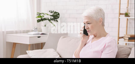 Infelice preoccupato senior Donna che parla al telefono Foto Stock