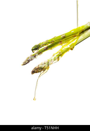 Versare olio su asparagi germogli. Foto Stock