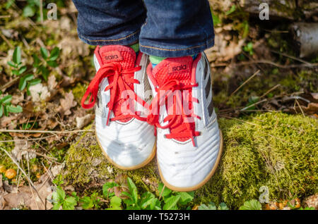 Vista ravvicinata di un giovane bambino trainer Adidas scarpe. Foto Stock