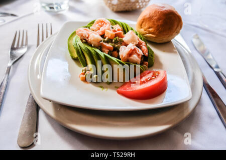 Decorate graziosamente fette di avocado insalata di gamberetti sulla piastra da pranzo Foto Stock