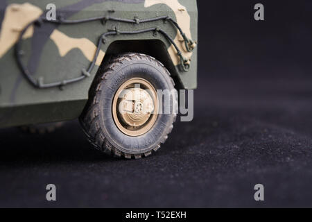 Militare russo di mimetizzazione blindato jeep Tiger. Primo piano. Scala in plastica modello su sfondo scuro. Ruota posteriore. Spazio di copia Foto Stock