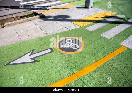 Il colore della segnaletica stradale per i ciclisti all'incrocio che indica la direzione di movimento dei ciclisti, indicato da un cartello tondo e una cassaforte crosswalk lin Foto Stock