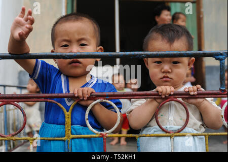 12.08.2012, Wonsan, Corea del Nord, Asia - Corea del Nord i bambini sono sventolando da una terrazza dei bambini Asilo nido presso la cooperativa Chonsam Farm. Foto Stock