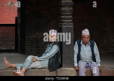 Kathmandu, Nepal - Maggio 06, 2017: due locali uomini nepalese siede rilassanti in Bhaktapur Durbar Square area. Foto Stock