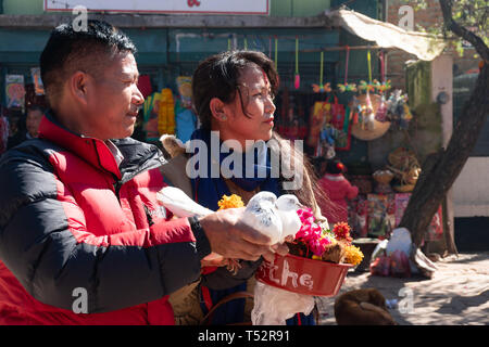 Gorkha, Nepal - Novembre 04, 2017: giovane adempiere la loro offerta alla dea rilasciando white piccioni in piedi di fronte a Manokamana devi tempio. Foto Stock