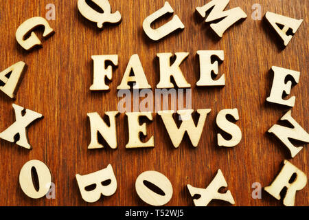Fake news da lettere di legno sulla scrivania. Foto Stock