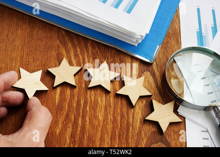 Valutazione aziendale concetto di tasso. Cinque stelle e una relazione finanziaria. Foto Stock