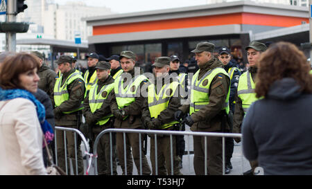 Riga di polizia è di guardia all'ingresso della piazza nei pressi di Kiev Olympiyskiy Stadium al dibattito presidenziale evento. Folla e corpi di polizia in azione. Foto Stock