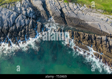 Mare di onde che si infrangono sulla barriera corallina e sulla costa di Sonabia, Spagna Mare cantabrico - drone vista aerea - lunga esposizione Foto Stock