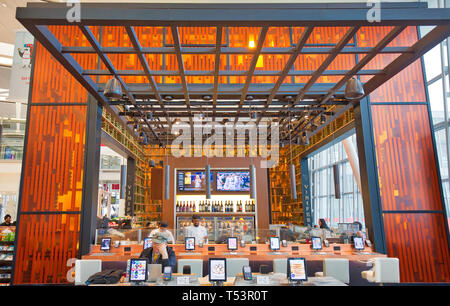 Toronto, Canada-April 10, 2019: Moderna Toronto Pearson aeroporto partenza sale di attesa con duty free, negozi e ristoranti aree piene di passeggeri Foto Stock