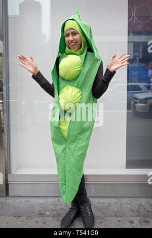 Un bellissimo modello indiano vestito come un pea pod in posa per una foto su 34th ST. in Manhattan. Lei era la promozione Peapod supermercato forniture alimentari. Foto Stock