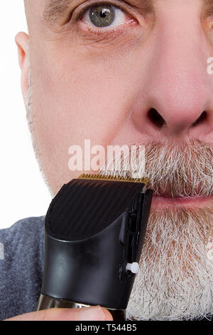 Grigio-uomo dai capelli rade la barba con un rasoio elettrico Foto Stock