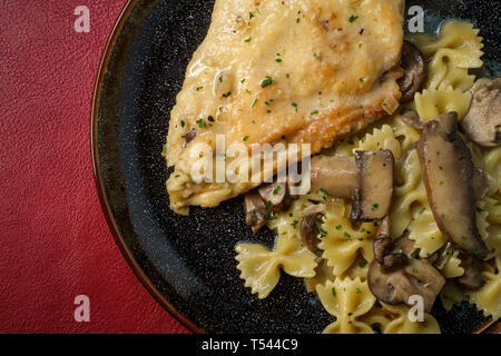 Cucina italiana pollo al marsala con funghi in una crema a base di vino e whisky salsa farfalle di pasta Foto Stock