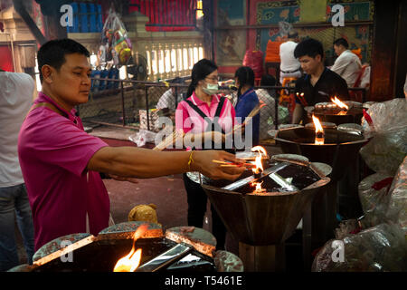 Thailandia, Bangkok, Thanon Tanao, Khwaeng San Chao Pho Sua, Xuantian Shangdi tempio, adoratore di illuminazione bastoncini di incenso su fiamma aperta Foto Stock