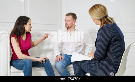 Famiglia di fronte alla difficoltà di relazione. Coppia giovane visita professionale terapista coniugale office, lottando con ogni altra terapia a sessione. Foto Stock