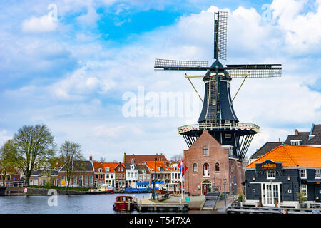 HAARLEM, Paesi Bassi - 9 Aprile 2016: De Adriaan tradizionale mulino a vento olandese sul canale d'acqua nei Paesi Bassi. Foto Stock