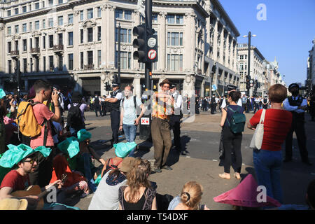 Londra, Regno Unito. Xx Apr, 2019. I membri del pubblico guarda come polizia rimuovere i manifestanti da una zona nel centro di Oxford Circus quale è stata occupata dagli attivisti dalla ribellione di estensione per quasi una settimana Credito: amer ghazzal/Alamy Live News Credito: amer ghazzal/Alamy Live News Credito: amer ghazzal/Alamy Live News Foto Stock