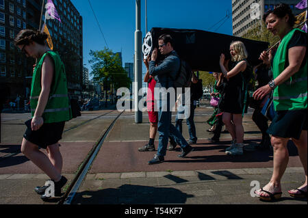 Rotterdam, Paesi Bassi. Xx Apr, 2019. Un gruppo di attivisti sono visto che trasportano una bara durante la dimostrazione. Una processione funebre è stata effettuata mediante il movimento internazionale, estinzione della ribellione di Rotterdam. Con questa azione, il movimento è esigente il governo olandese a dichiarare una emergenza clima atto a realizzare un piano di Delta Clima per Rotterdam, netta pari a zero emissioni di CO2 nel 2025, tra cui il porto di Rotterdam. Credito: SOPA Immagini limitata/Alamy Live News Foto Stock