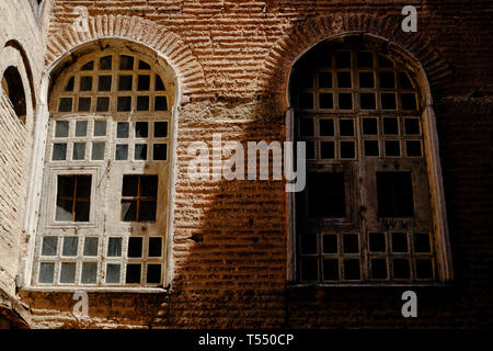 Due finestre in ombra e luce sulla piastrella un muro di mattoni Foto Stock