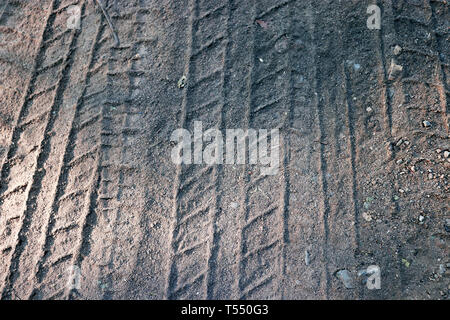Tracce di pneumatici sulla sabbia in tono bruno. Sfondo astratto e pattern. Foto Stock