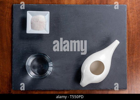 Set per pulizia nasale con neti pot, medicina ayurvedica sistema su un nero ardesia, vista dall'alto Foto Stock