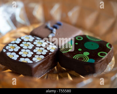 Close up di fantasia, decorate latte e cioccolato scuro fotografato con una profondità di campo ridotta. Foto Stock
