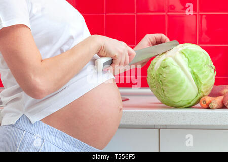 Donna incinta la preparazione di alimenti Foto Stock
